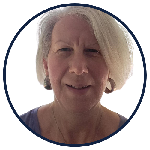 A portrait of Nikki Gianni, a smiling leadership coach with short white hair, set against a simple background.