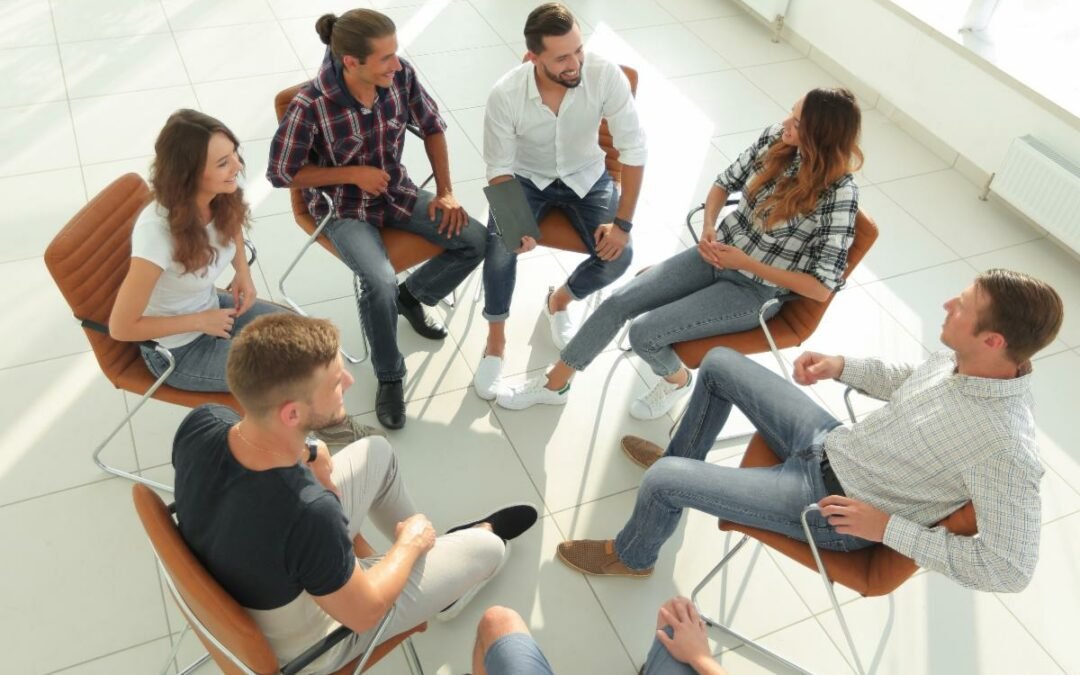 Group of six individuals, including a leadership architect, engaged in a conversation while seated in a circle.